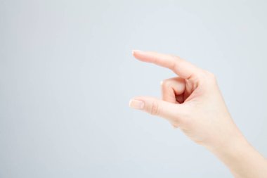 Beyaz arka planda el hareketi yapan kadınların yakın çekimi. 