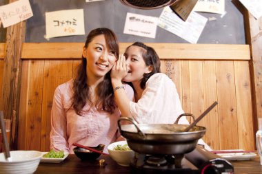 Restoranda dedikodu yapan genç kadınlar. 