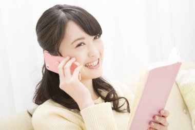 Akıllı telefondan konuşan gülümseyen Asyalı kadın. Toplantı programına bakıyorum. randevu alınıyor