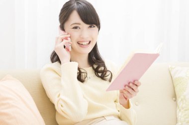 Akıllı telefondan konuşan gülümseyen Asyalı kadın. Toplantı programına bakıyorum. randevu alınıyor