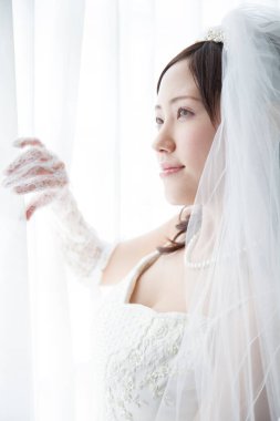 Pencere kenarında duvağı olan güzel Japon gelini.