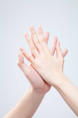 Beyaz arka planda el hareketi yapan kadınların yakın çekimi. 