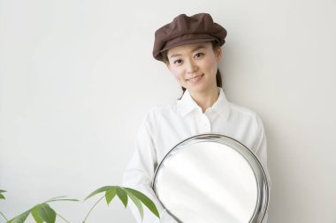 Metal tepsiyle genç ve güzel Japon garsonun portresi.