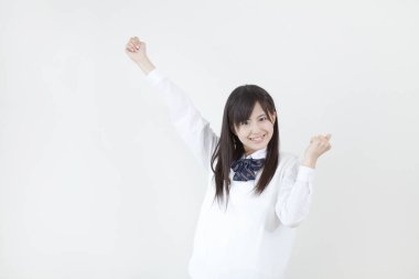Okul üniformalı genç Japon kızın stüdyo portresi.