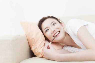 Genç Japon kadın oturma odasında dinleniyor.