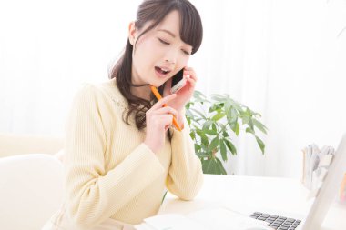 Akıllı telefondan konuşan gülümseyen Asyalı kadın. Toplantı programına bakıyorum. randevu alınıyor