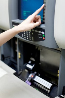 Kadın eli otomatik makinenin düğmesine basıyor.