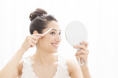 Yüzünü tıraş eden Asyalı güzel bir kadın. 