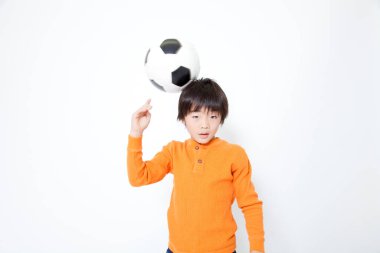 Futbol topu taşıyan Asyalı bir çocuğun portresi. 