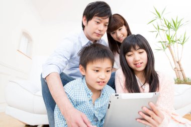 Asyalı bir aile tablet kullanıyor.