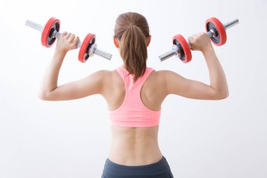 Dambılı spor yapan genç bir bayan.