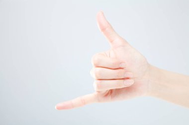 Beyaz arka planda el hareketi yapan kadınların yakın çekimi. 