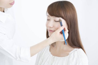 Güzellik salonunda makyaj yapan Asyalı güzel bir kadının yakın çekimi. 