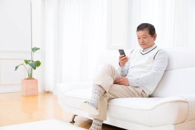 Üst düzey Asyalı adam cep telefonu kullanıyor.