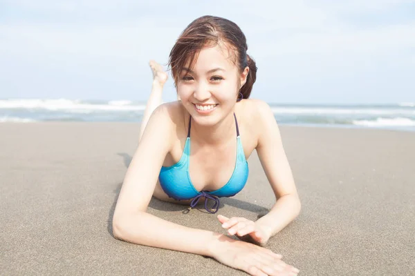在夏天的海滩上 年轻的亚洲女人躺在沙滩上 — 图库照片