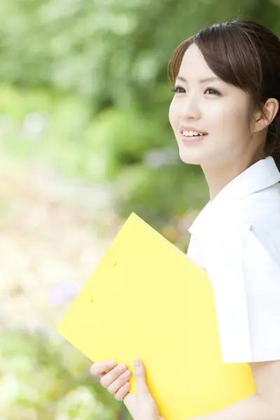 asian student girl with white uniform and folder at park.