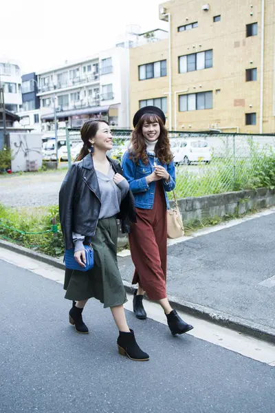 Şehirde yürüyen iki genç kadın.