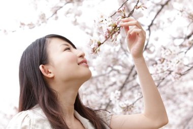 Kiraz çiçekleri olan genç bir kadın