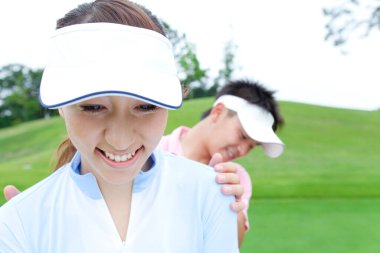 Golf oynayan genç Japon çift.