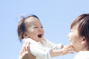 Asyalı anne ve küçük oğlu parkta.