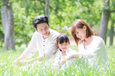 Çimlerin üzerinde oturan bir aile 