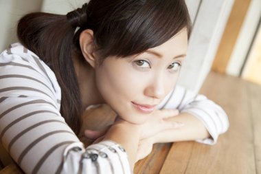 Pencere kenarında oturan genç bir kadın. 