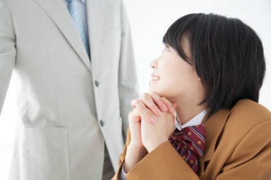 Genç Asyalı kız okul üniforması giyiyor. Sınıfta öğretmenle ders çalışıyor.