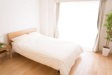 Yatak odasında beyaz rahat yatak