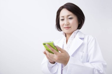 Kadın doktor akıllı telefon kullanıyor.