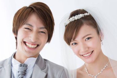 Kameraya gülümseyen Asyalı gelin ve damadın portresi