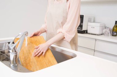 Kadınlar mutfak lavabosunda sofra takımlarını yıkıyor.