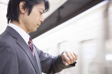 Yetişkin Japon iş adamının portresi metroda çalışacak.