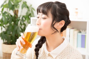 Arka planda bira içen Asyalı kadın