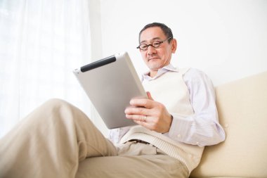 Evde dijital tablet kullanan adam 