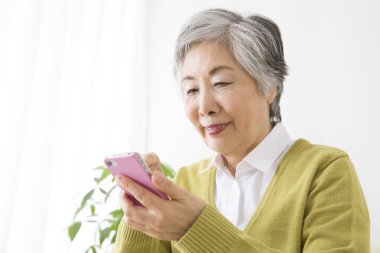 Usta Asyalı kadın akıllı telefon kullanıyor.