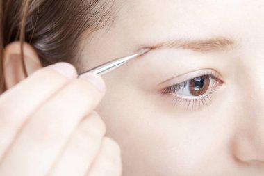 Kadın fırçayla kaş pudrası sürüyor. 