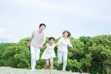 Parkta oynayan genç ebeveynler ve çocuklar