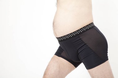 Siyah iç çamaşırlı şişman adam beyaz arka plana karşı. 