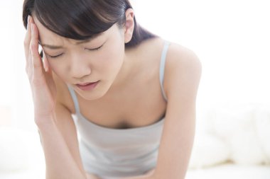 Asyalı kadın baş ağrısı çekiyor. 