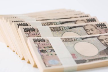 Beyaz arka planda yığınla Japon banknotları 