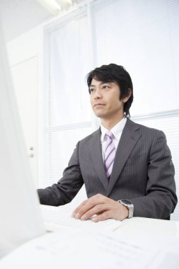 Ofiste çalışan kendinden emin genç Japon işadamı.