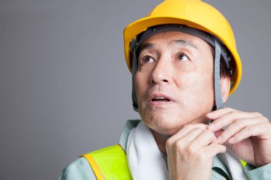 Beyaz arka planda izole edilmiş Asyalı bir inşaat işçisinin stüdyo fotoğrafı.