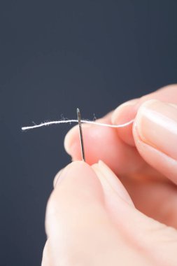 Kadın eli iplikli iğne.