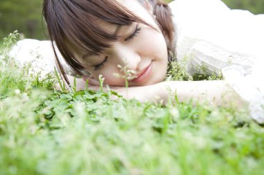Japon kadın çimlerin üzerinde yatıyor. 