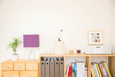 Kitaplar ve diğer şeylerle dolu bir raf. 