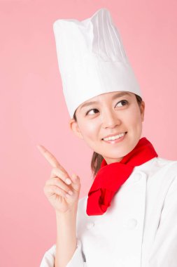 Genç Asyalı kadın şef üniforması giyiyor.