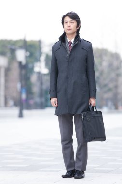 Asyalı işadamı sokakta yürüyor