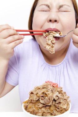 Şişman Asyalı kadın et yiyor. Stüdyo resmi