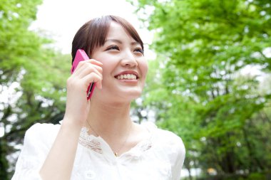 Japon kadın cep telefonuyla konuşuyor.