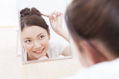 Aynada yansımasına bakan bir kadın.